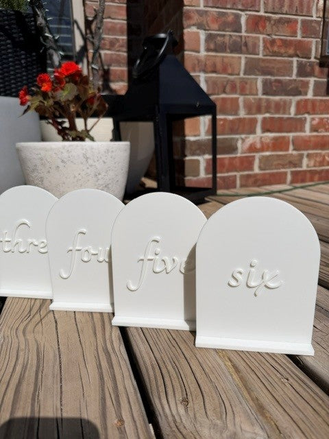 White arch table numbers styled group shot - reusable PLA table numbers for weddings and events