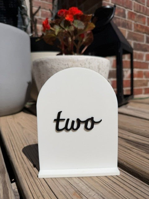 Black arch table number 2 standing upright for event or wedding table setting
