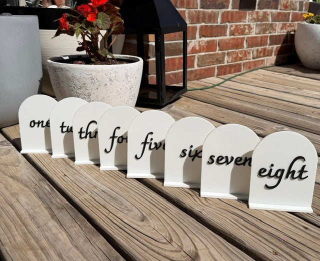 Black arch table numbers set displayed together for wedding and event table decor