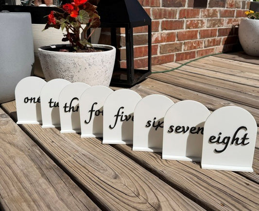 Black arch table numbers set displayed together for wedding and event table decor