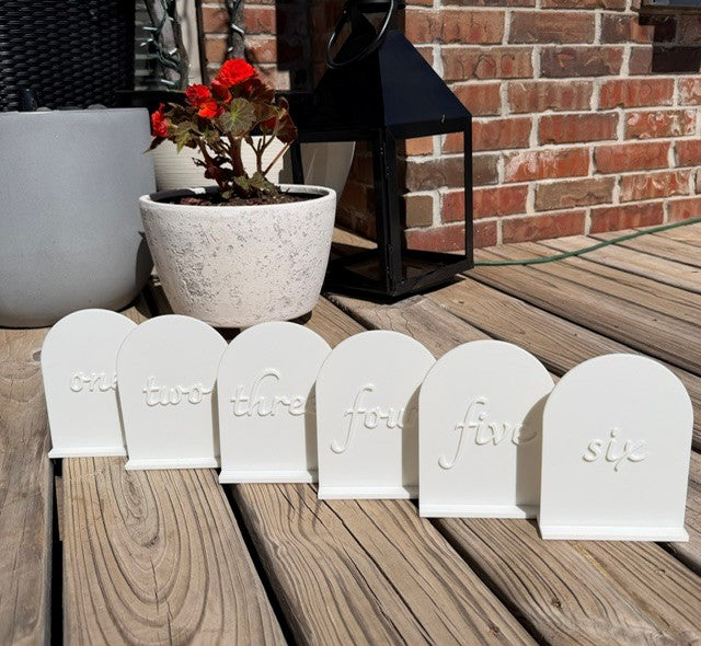 White arch table numbers set displayed together for wedding and event table decor