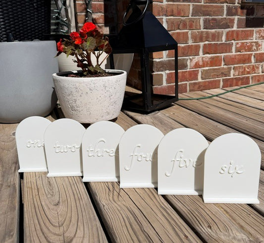 White arch table numbers set displayed together for wedding and event table decor
